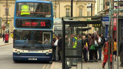 The number 55 double decker bus picking up passengers from a town centre bus stop