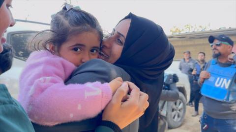 A woman hugs a girl after a family reunion organised by the UN