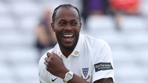 Fast bowler Jofra Archer smiles while playing for Sussex