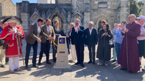 Officials from Southampton City Council and the Galician authorities next to the milestone.