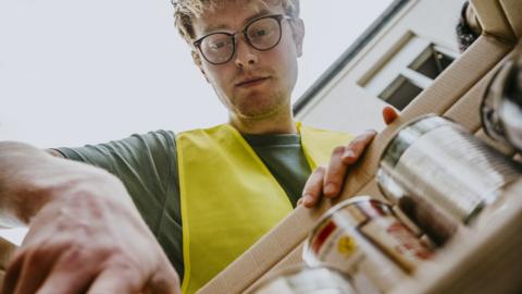 Man puts tins into box