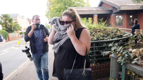 Hayley Jones covers her face as she arrives at Wimbledon Magistrates' Court