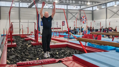 Peter Quinney, an elderly man juping in the air having bounced on a trampoline. 