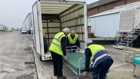 Three men loading a bed