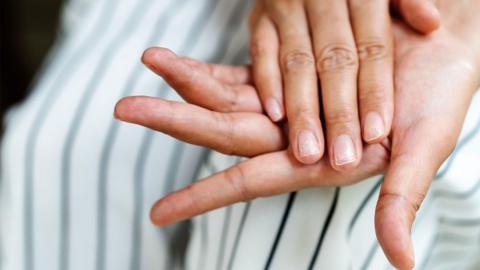Close-up of two hands - one is on top of the other.