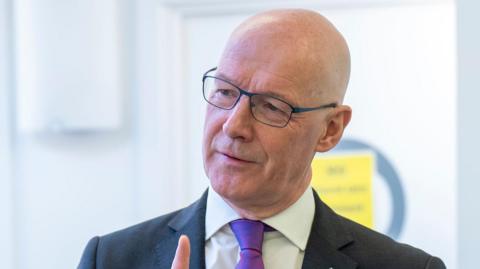 John Swinney head and shoulders shot wearing a suit and tie