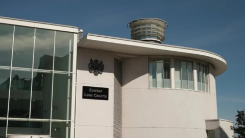 A white court building with a sign saying 'Exeter Crown Court'