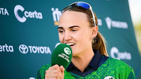 Gaby Lewis being interviewed holding a Cricket Ireland microphone after an international with Pakistan