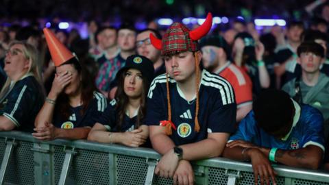 Disappointed Scotland fans in fan zone.