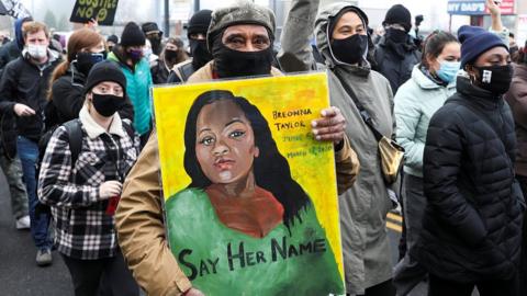 Protester holding sign with an image of Breonna Taylor