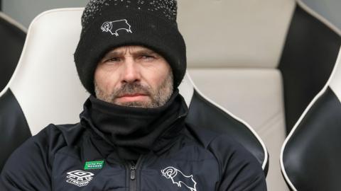 Derby boss Paul Warne sat in the dugout at Pride Park