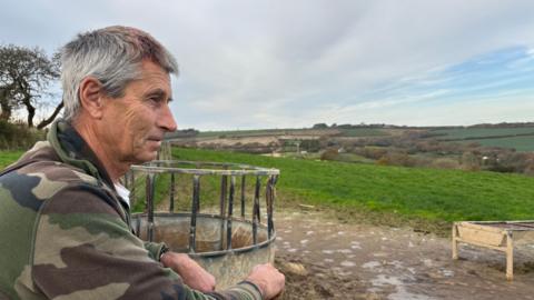 Farmer Charlie Gould looks across green fields.