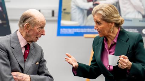 The Duchess of Edinburgh and The Duke of Kent speaking to each other.  