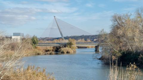 A red cable-stay bridge spanning the River Tagus on an autumn day