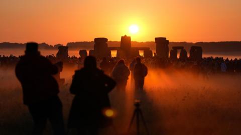 Crowds watch the sun rise above Stonehenge on the summer solstice