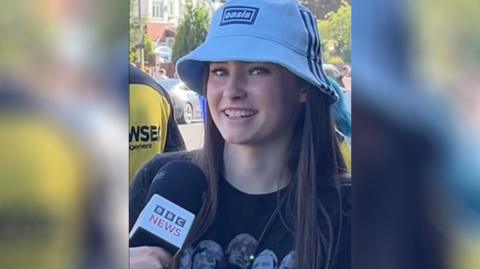Teenage girl in Oasis bucket hat and t-shirt