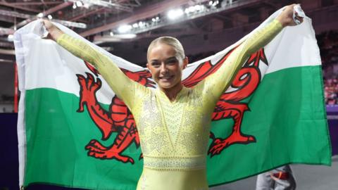 Ruby Evans lifts Welsh flag after winning gold medal