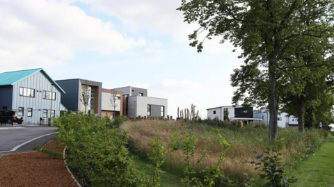 A general view picture of a handful of self-build houses opposite a wooded area on the Graven Hill estate.