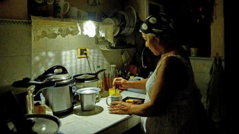 Havana resident Araselys Rodriguez makes coffee during the blackout