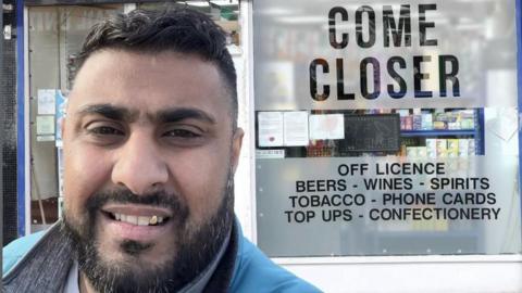 Mr Nazir standing outside his shop