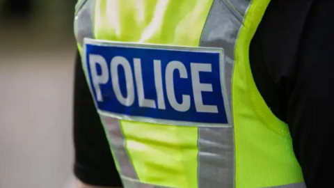 A close up of a generic police stab vest, with 'Police' in hi vis lettering across the back.