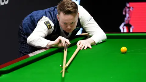 Shaun Murphy plays a shot with the rest