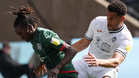Ben Cabango of Swansea City (right) tackles Domingos Quina of Barnsley