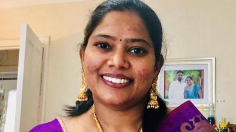 Chithra Vanmeeganathan, a woman with shoulder-length dark hair wearing gold earrings and purple clothing, smiling at the camera