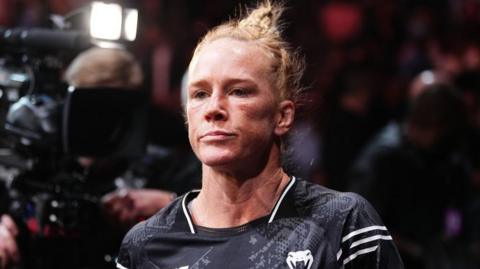 Holly Holm is dressed in UFC gear as she enters the octagon