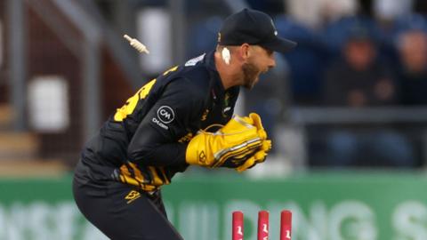 Glamorgan's Chris Cooke removes the bails for a runout