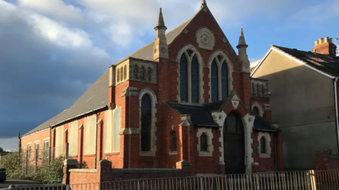 A general view of the Methodist church, with wooden boards covering at least four windows on its left side