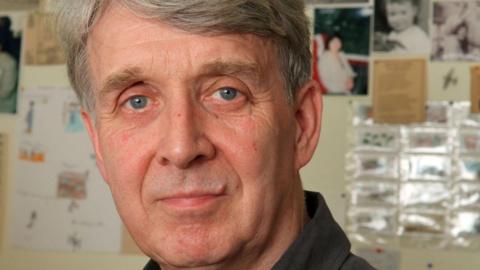 Portrait of Allan Ahlberg staring directly at the camera. He has blue eyes and grey hair. 