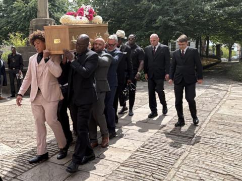 The coffin of David "Syd" Lawrence is carried into St Mary Redcliffe Church in Bristol