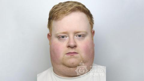 Daniel Wyke in police custody in a white top