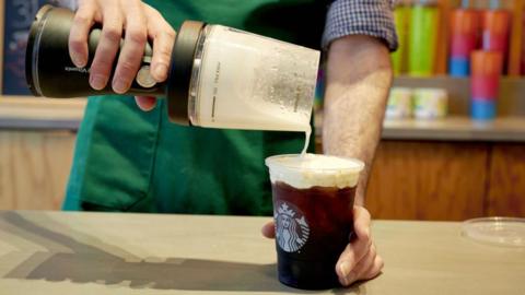 A barista uses a portable blender to make cold foam at a Starbucks location in New York, on Thursday, 17 August, 2023.