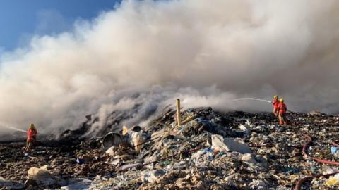 Firefighters putting the landfill fire out