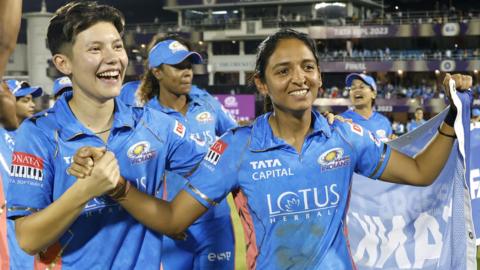 Issy Wong and Harmanpreet Kaur celebrate winning the WPL