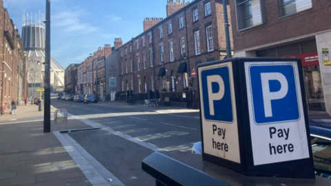An image of Hope Street in Liverpool, showing a row of Georgian buildings and the Metropolitan cathedral in the background. A parking meter is in the foreground of the photo. 