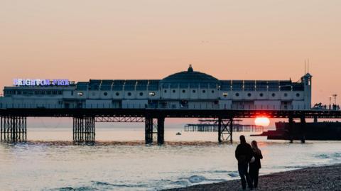 Brighton Pier with the sun setting below it