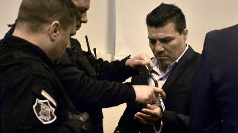 In this handout photo released by Telam, Argentine former boxer Carlos Baldomir (R) have his handcuffs removed at a court in Santa Fe, Argentina on July 31, 201