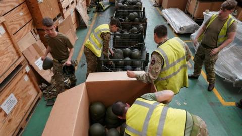 Soldiers sorting helmets