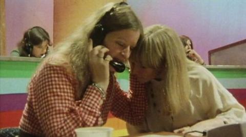 Lesley Judd listens in to a phone call with a phone operator.