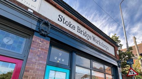 A building with a sign that reads Stoke Bridge Workshops.