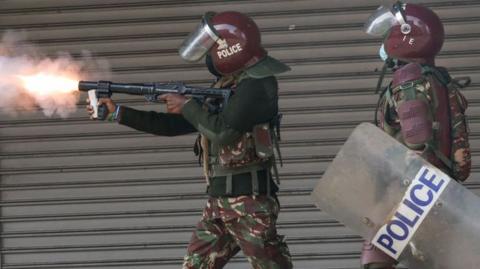 Police fire tear gas at protesters.