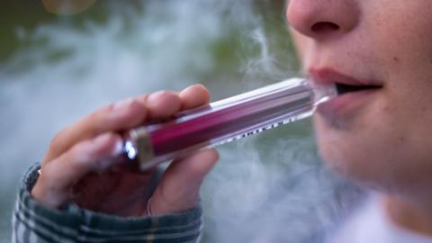 A close up image of a person vaping