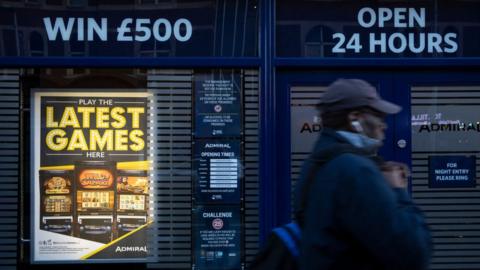 A man walks past a casino advertising fixed odds betting terminals