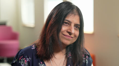 Susan Kohli wearing a navy flowery top.