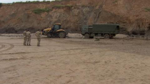 Tractor pulls bomb disposal truck off beach