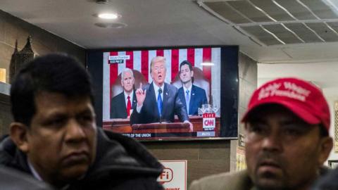 US President Donald Trump is seen on a television set in a restaurant in New York