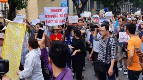 Protesters carry a banner reading "No Leasing Land to China even for Anytime" in Hanoi